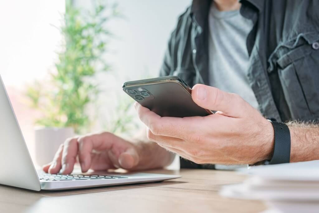 Mann auf der Arbeit hält Handy in der Hand